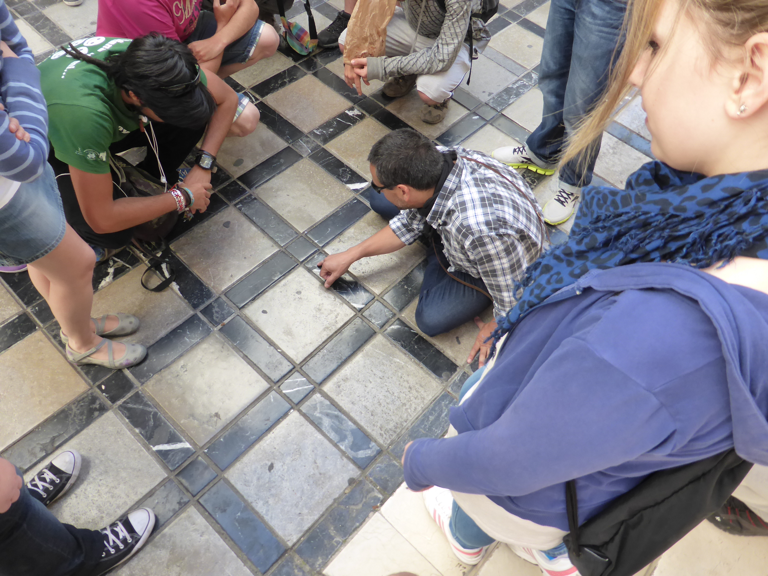 Participants huddled around examining fossils in the city's pavements