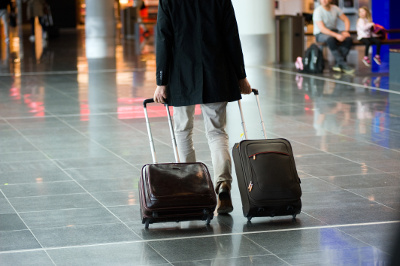 A man carrying suitcases through an airport terminal