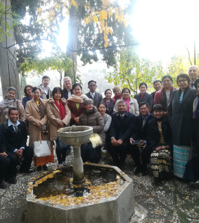 Representatives from the different partner universities posing for a photo outside beside a fountain