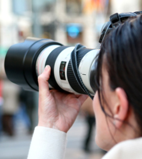 A photographer tacking photos with a long-focus lens 