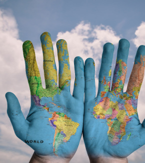 A map of the world painted on the palms of two hands