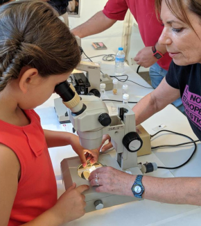 A researcher and a young girl conducting an experiment