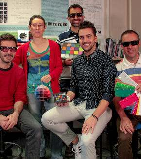 A team of researcher in a laboratory holding colour wheels and charts