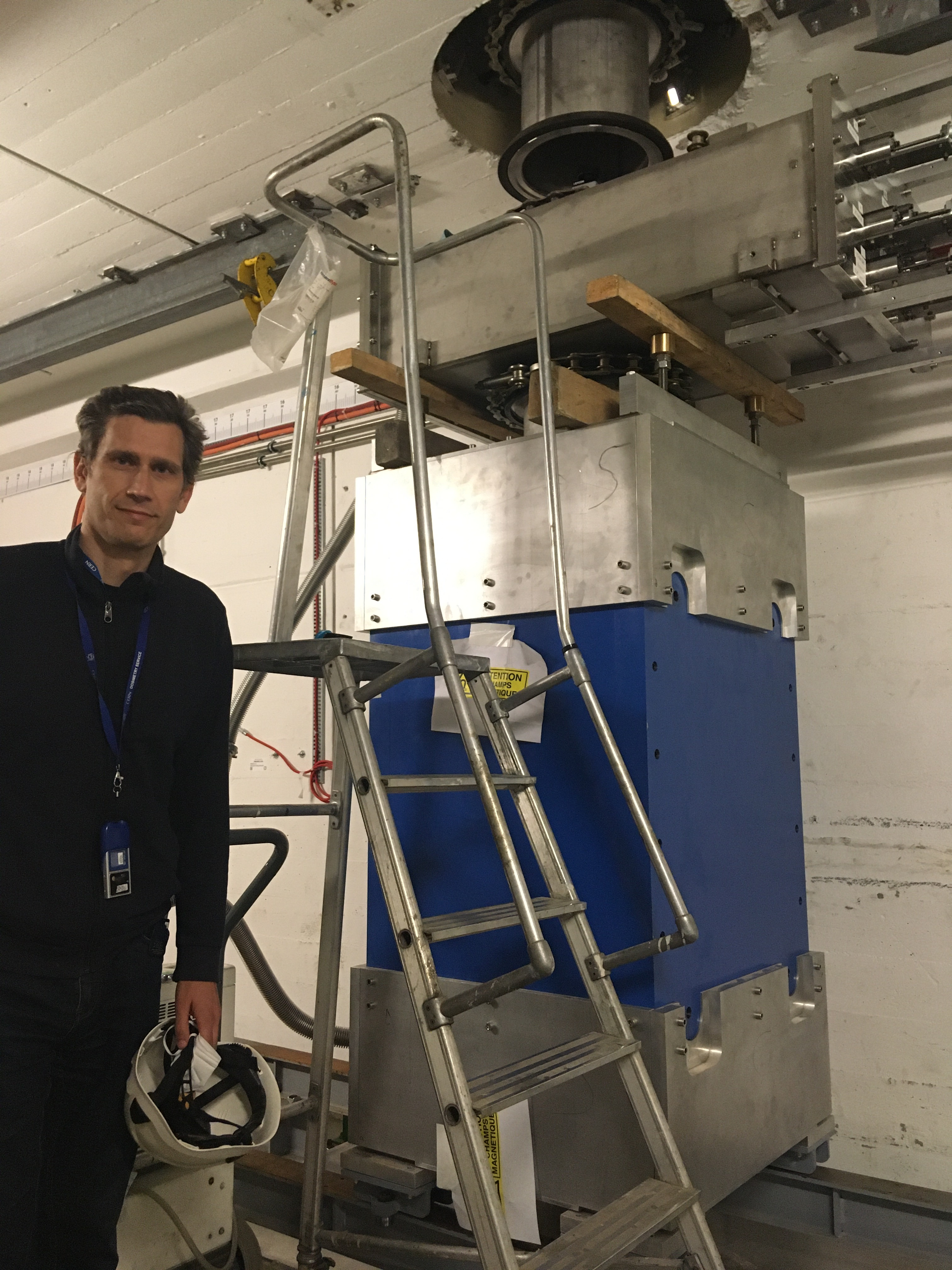 En la foto (mayo de 2021), Javier Praena durante las pruebas realizadas al imán (0.3 Tesla) utilizado en la línea vertical y situado a 10 metros sobre el blanco. El tubo en el techo guía a los neutrones, ya libres de partículas cargas, hacia la sala EAR2