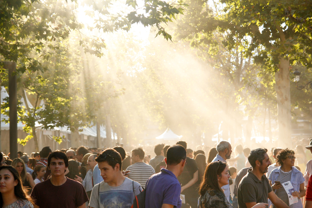 Throngs of people in an open space surrounded by marquees 