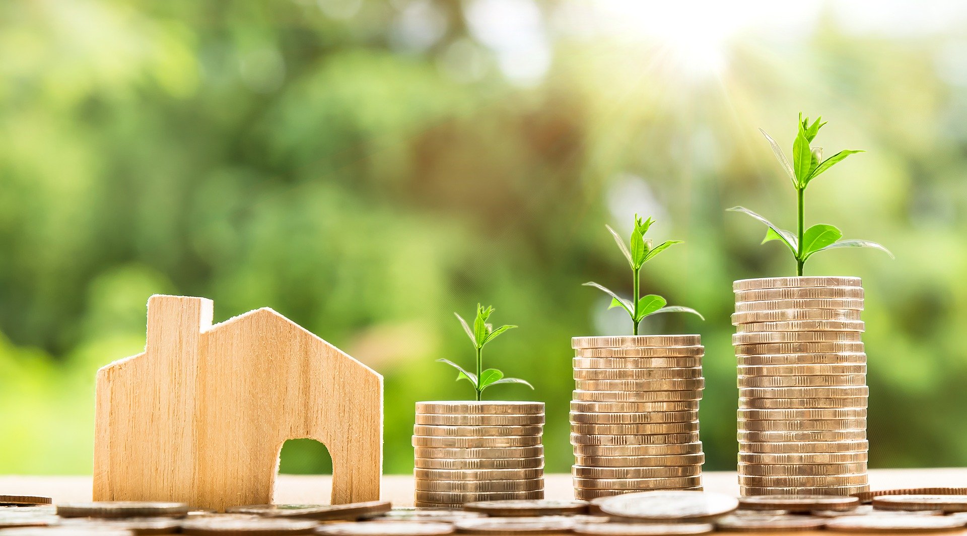 A small wooden house with stacks of coins beside it