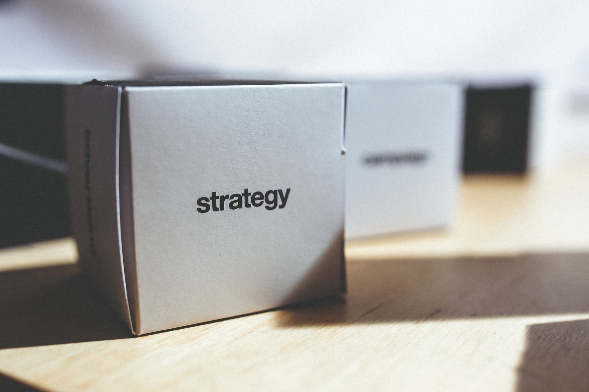A cardboard cube with "strategy" written on it