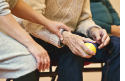 Two people sitting on a bench holding hands