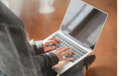 A woman typing on a laptop