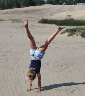 A woman doing a cartwheel on a beach