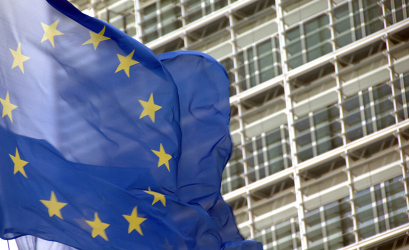 bandera de la Unión Europea ondeando con un edificio al fondo