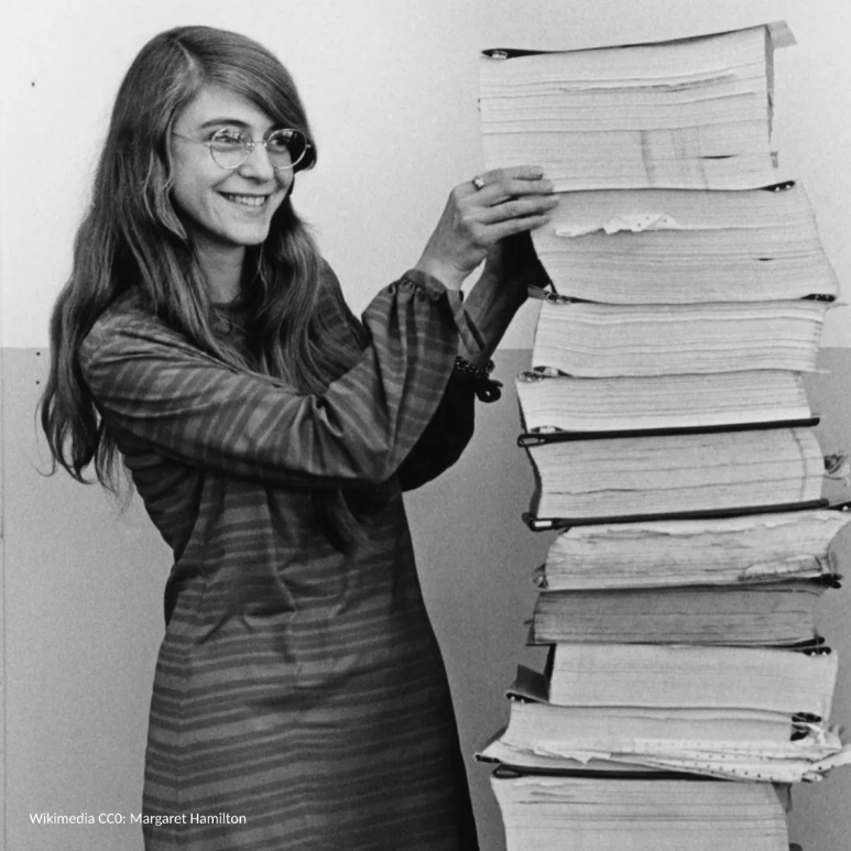 Mujer sostiene una pila de libros científicos