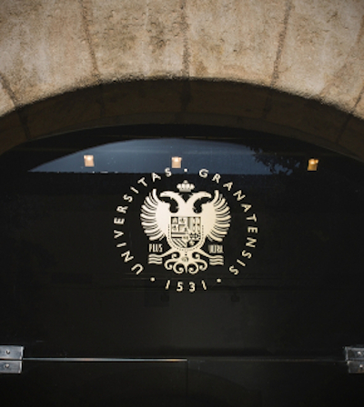 A glass door featuring the coat of arms of the UGR