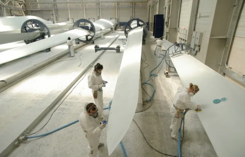 operarios pintando hélices de molinos eólicos