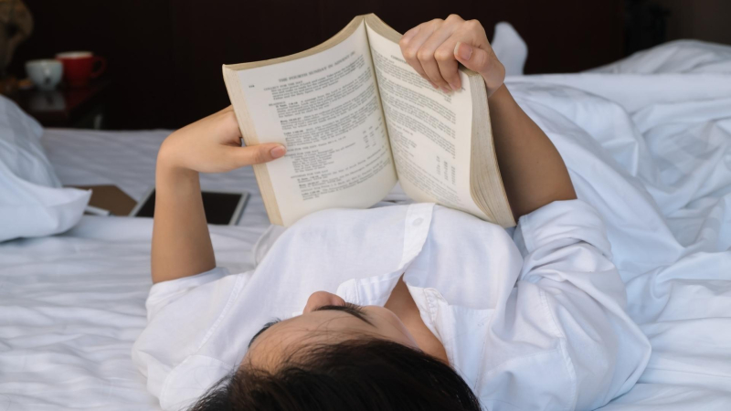 imagen de recurso: mujer leyendo, recostada en la cama