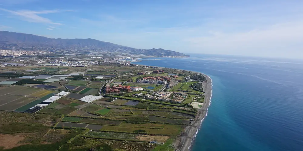 Aerial view of a low-lying coastal plain with a town by the sea